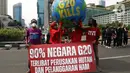 Aktivis iklim melakukan teatrikal dengan membawa bola dunia saat aksi di kawasan Bundaran Hotel Indonesia, Jakarta, Minggu (13/11/2022). Aksi yang digelar berbarengan dengan penyelenggaraan G20 ini meminta pemimpin dunia menemukan solusi bersama atas kondisi ekonomi global. (Liputan6.com/Herman Zakharia)