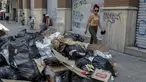 Seorang wanita berjalan melewati tumpukan sampah akibat pemogokan petugas sampah di Santiago (14/11/2019). Protes kekerasan meletus di ibukota Chile, Santiago, pada Selasa ketika mata uang negara itu turun ke level terendah dalam sejarah. (AFP/Javier Torres)