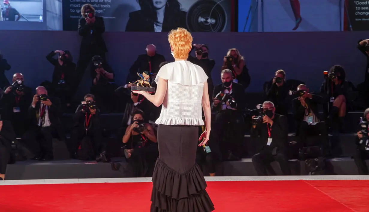 Aktris Tilda Swinton berpose dengan trofi Golden Lion for Lifetime Achievement pada upacara pembukaan Venice Film Festival ke-77 di Venesia, Italia, Rabu (2/9/2020). Venice Film Festival tahun ini akan berlangsung dari 2 September hingga 12 September. (AP Photo/Domenico Stinellis)