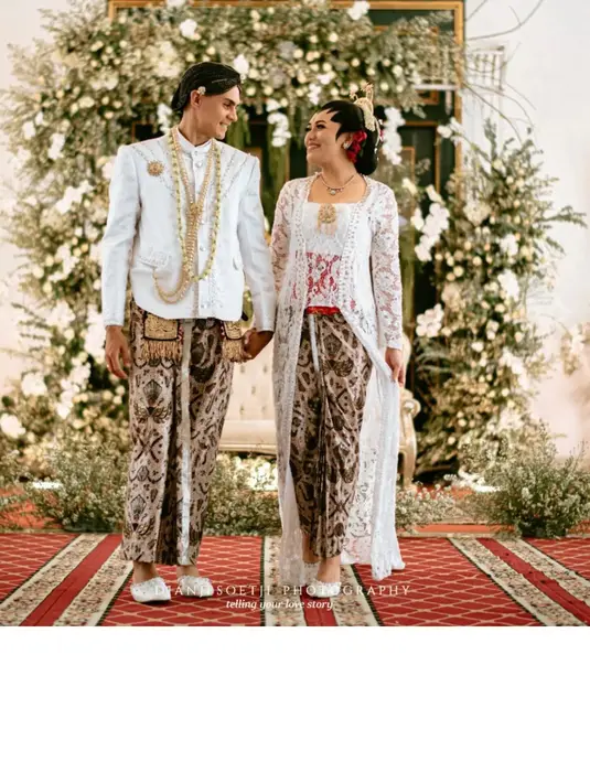 Sementara Christian Rontini mengenakan beskap warna putih senada, lengkap dengan blangkon dan untaian bunga melati di lehernya. [Foto: IG/djanjisoetji.photography]