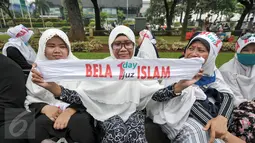 Demonstran perempuan menunjukkan spanduk saat aksi damai di pinggir taman Jalab Medan Merdeka Selatan, Jumat (4/11). Ratusan ribu massa aksi damai melakukan aksi menuntut penegakan hukum kasus dugaan penistaan agama. (Liputan6.com/Yoppy Renato)