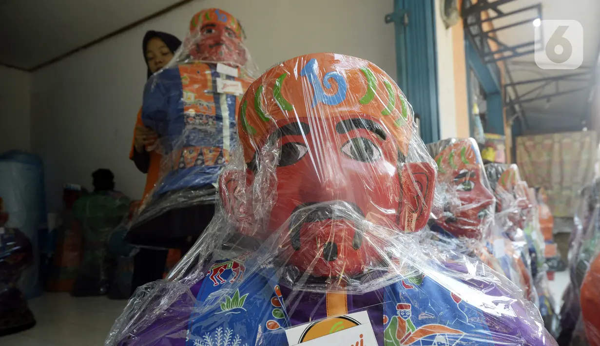 Seorang wanita membawa ondel-ondel untuk ditata di Kawasan Perkampungan Budaya Betawi, Setu Babakan, Jagakarsa, Jakarta Selatan, Selasa (28/7/2020). Ondel-ondel tersebut dijual mulai dari Rp 35 ribu hingga Rp hingga 8 juta. (merdeka.com/Dwi Narwoko)