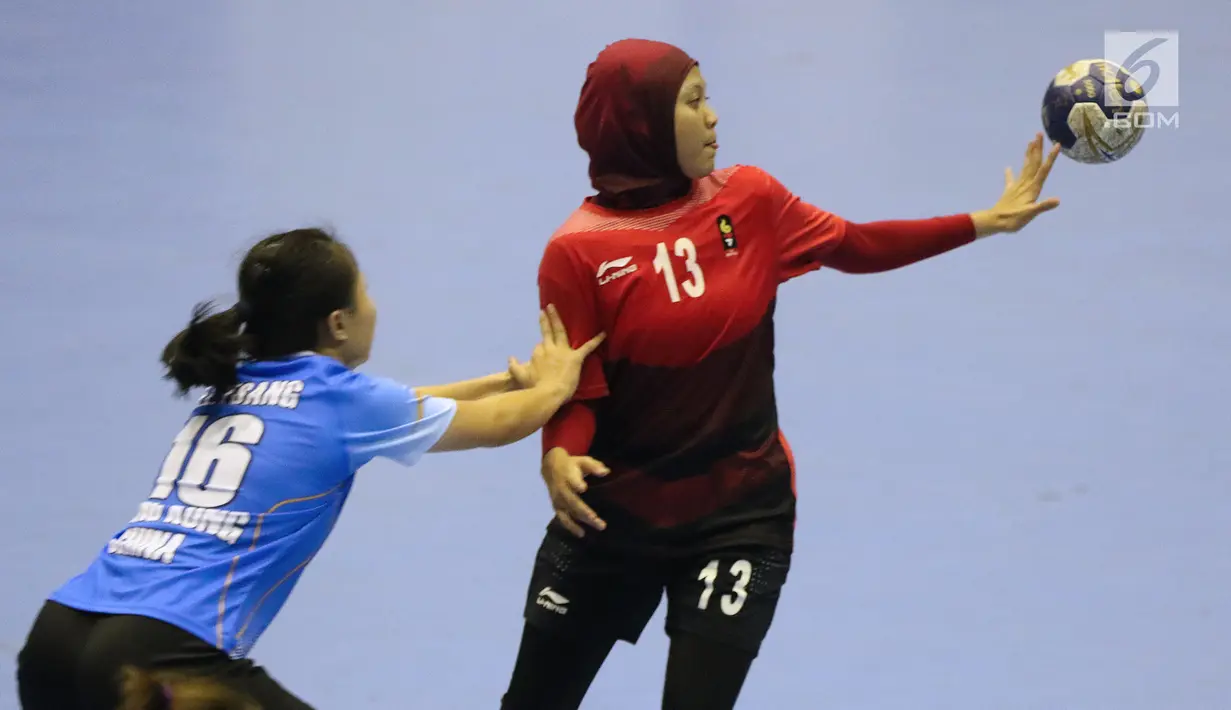 Pemain bola tangan putri Indonesia, Putri Dwi Merdekawati (kanan) berebut bola dengan Tsang Yuen Lam (Hong Kong) pada kualifikasi 7-8 Bola Tangan Putri Asian Games 2018 di Jakarta, Rabu (29/8). Indonesia menyerah 16-30. (Liputan6.com/Helmi Fithriansyah)