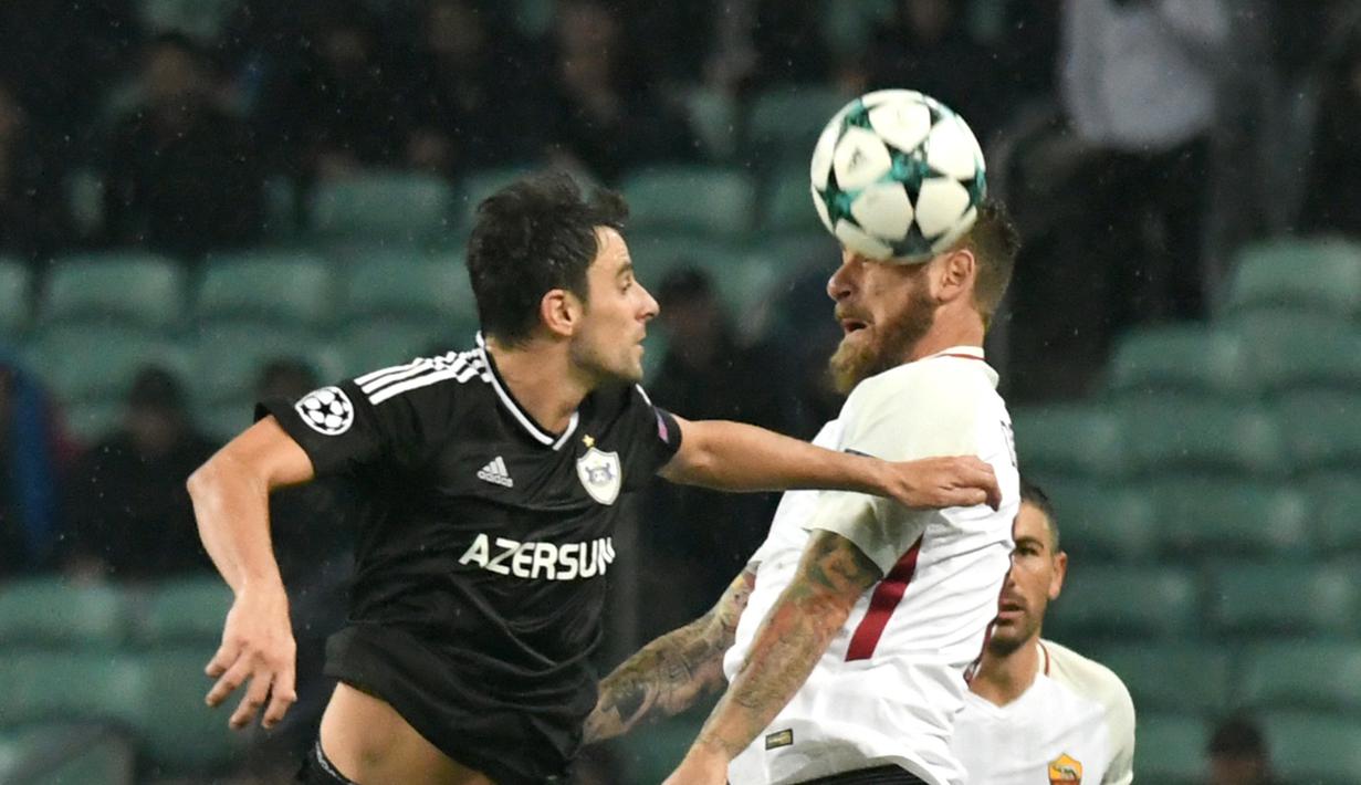 Pemain Qarabag FK. Michel (kiri) berduel dengan pemain AS Roma, Daniele De Rossi pada laga grup C Liga Champions di Baki Olimpiya Stadionu, Baku, (27/9/2017). AS Roma menang 2-1. (AFP/Vano Shlamov)
