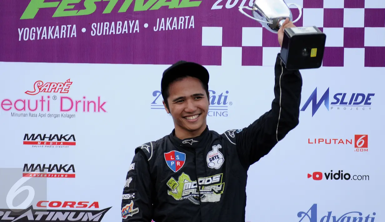 Drifter Indonesia, Adwitya Amandio mengangkat piala juara ketiga Achilles Motorsport Festival 2015 di JIExpo Kemayoran Jakarta, Sabtu (19/12/2015). Achilles Motorsport Festival 2015 digelar di tiga kota. (Liputan6.com/Helmi Fithriansyah)