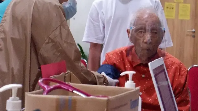 Kakek berusia 104 tahun menerima suntikan vaksin Covid-19 di Rumah Sakit Vania, Bogor pada Selasa, 23 Maret 2021.