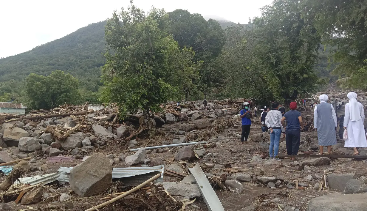 Warga memeriksa kerusakan usai banjir bandang di Desa Ile Ape, Pulau Lembata, Nusa Tenggara Timur, Selasa (6/4/2021). Tim penyelamat terus menggali puing tanah longsor untuk mencari korban yang terkubur usai bencana banjir bandang. (AP Photo/Ricko Wawo)
