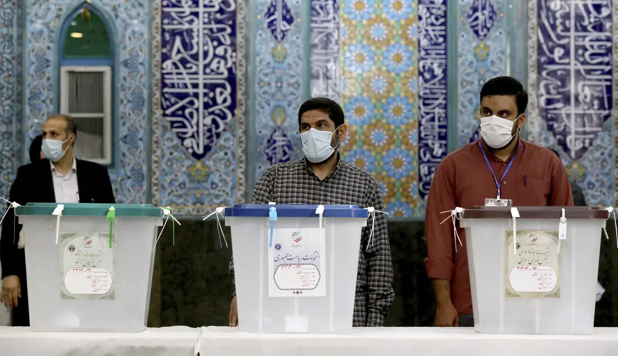 Pejabat pemilihan Iran menunggu pemilih selama pemilihan presiden di sebuah tempat pemungutan suara di Teheran, Iran, Jumat (18/6/2021). Warga Iran mulai memberikan suaranya dalam pemilihan presiden. (AP Photo/Ebrahim Noroozi)