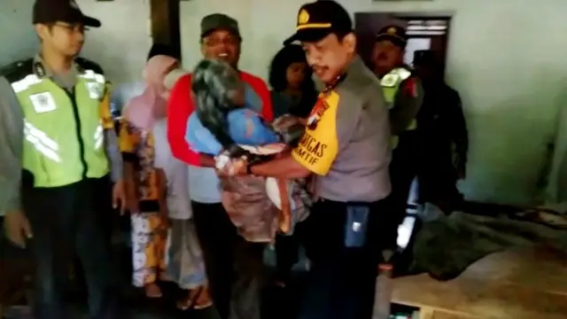 Polisi dan warga menggendong Nenek Sainem ke mobil patroli dan membawanya ke rumah sakit. (Foto: Liputan6.com/Polres Kebumen/Muhamad Ridlo)