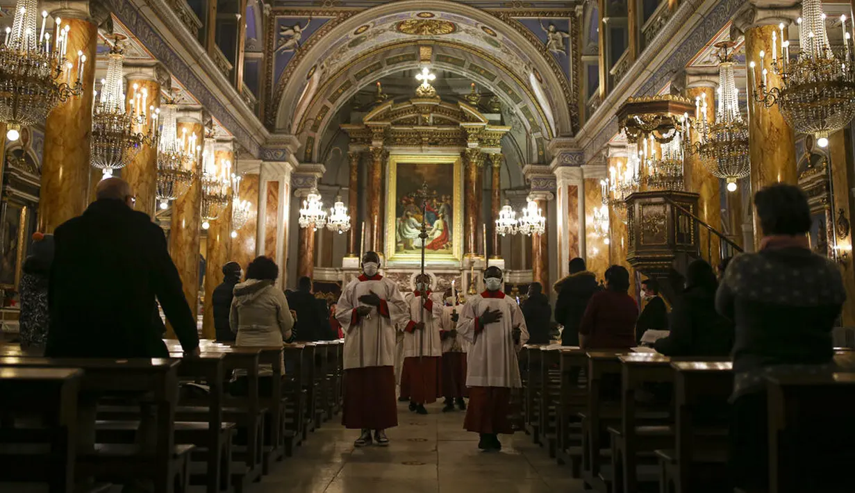 Orang-orang memakai masker untuk membantu mengekang penyebaran COVID-19 saat misa pada malam Natal di Katedral Katolik Roh Kudus atau Katedral St. Esprit, Istanbul, Turki, Kamis (24/12/2020). Natal tahun ini dirayakan oleh umat Kristiani dunia di tengah pandemi COVID-19. (AP Photo/Emrah Gurel)