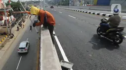 Pekerja mengecat tembok jembatan layang (flyover) simpang gaplek di Pamulang, Tangerang Selatan, Jumat (15/5/2020). Beroperasinya flyover sepanjang 446 meter yang menghubungkan Ciputat- Parung itu diharapkan membantu mengurai kemacatan yang kerap terjadi di kawasan tersebut (merdeka.com/Arie Basuki)