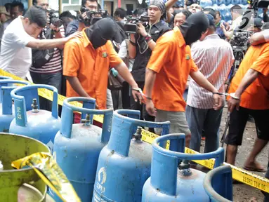 Tersangka penyuntikan tabung gas di Cipayung, Jakarta, Selasa (22/1). Polda Metro Jaya menyita 1.200 tabung LPG ukuran 3 Kg, 242 ukuran 12 Kg, 14 selang pipa besi regulator pemindah isi gas dan 1 kantong segel tabung gas. (Liputan6.com/Faizal Fanani)