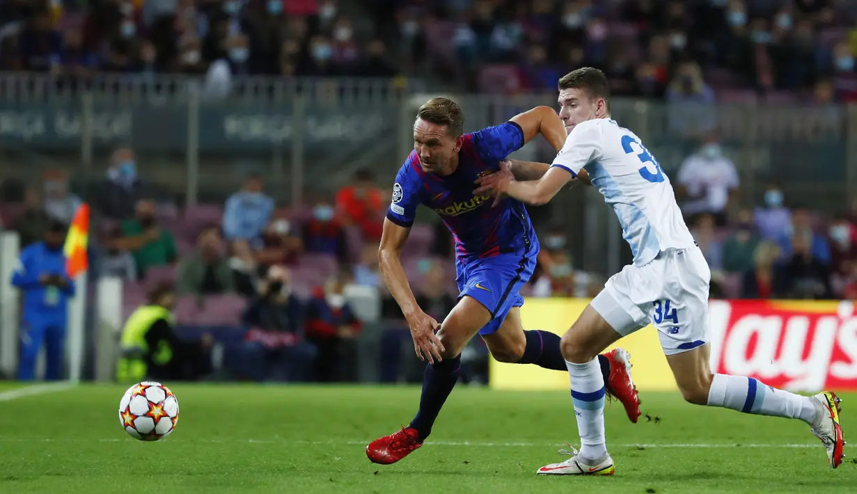 Bek Barcelona, Luuk de Jong (kiri) berebut bola dengan pemain Dinamo Kyiv, Oleksandr Syrota pada pertandingan lanjutan Grup E Liga Champions di di stadion Camp Nou di Barcelona, Spanyol, Rabu (20/10/2021). Barcelona kini berada di peringkat ketiga klasemen dengan tiga poin. (AP Photo/Joan Monfort)