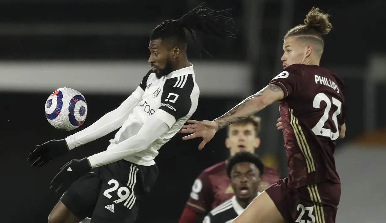 Gelandang Fulham, Andre-Frank Zambo Anguissa (kiri) mengontrol bola di depan gelandang Leeds United, Kalvin Phillips dalam laga lanjutan Liga Inggris 2020/2021 pekan ke-29 di Craven Cottage, London, Jumat (19/3/2021). Fulham kalah 1-2 dari Leeds United. (AP/Matt Dunham/Pool)