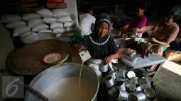 Pekerja menuangkan adonan kue keranjang ke cetakan di industri kue keranjang rumahan di Yogyakarta, (22/1). Jelang perayaan Imlek 8 Februari 2016, Permintaan produksi meningkat dari biasanya. (Boy Harjanto)