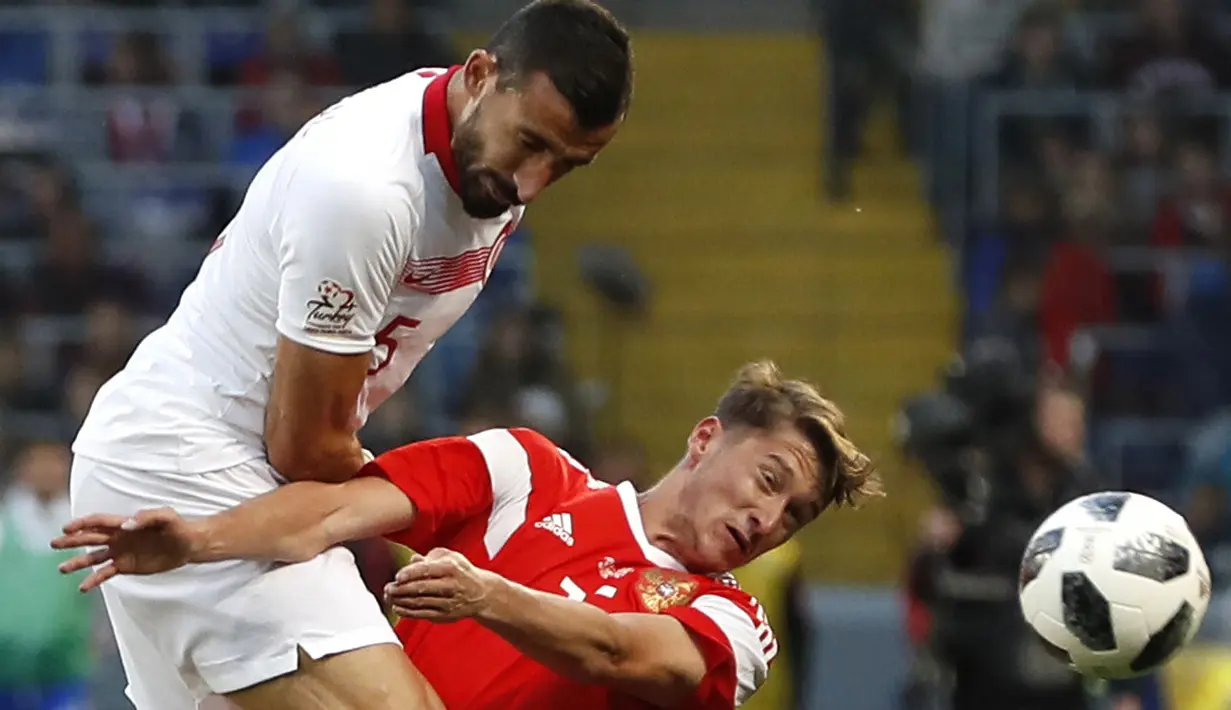 Aksi pemain Turki, Okay Yokuslu (kiri) menghalau bola dari pemain Rusia, Aleksey Miranchuk pada laga uji coba di VEB Arena stadium, Moskow, Rusia, (5/6/2018). Rusia bermain imbang 1-1. (AP/Pavel Golovkin)