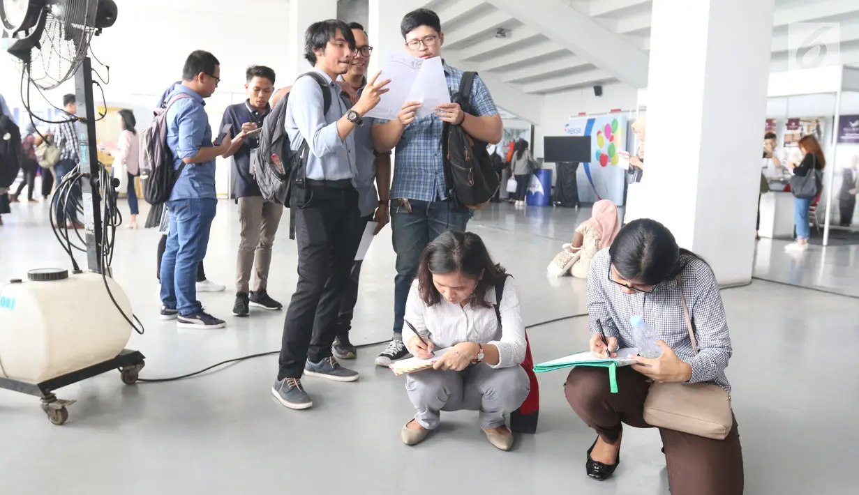 Pencari kerja mengisi data saat mengikuti Mega Career Expo 2019 di GBK, Senayan, Jakarta, Selasa (2/7/2019). Mega Career Expo 2019 berlangsung pada tanggal 2-3 Juli. (Liputan6.com/Angga Yuniar)