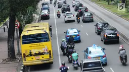 Pengendara motor melintas di sisi mobil parkir di jalur khusus motor di sekitar Jalan Medan Merdeka Barat, Jakarta, Kamis (1/3). Jalur yang seharusnya digunakan untuk pengendara motor tersebut hingga kini belum steril. (Liputan6.com/Helmi Fithriansyah)