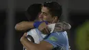 Penyerang Argentina Lionel Messi berpelukan dengan penyerang Uruguay Luis Suarez sebelum laga Kualifikasi Piala Dunia 2022 Zona Amerika Selatan di Monumental stadium, Senin (11/10/2021) pagi WIB. Duel ini menjadi momen reuni dua mantan pemain Barcelona, Messi dan Suarez. (Juan Mabromata/AFP)