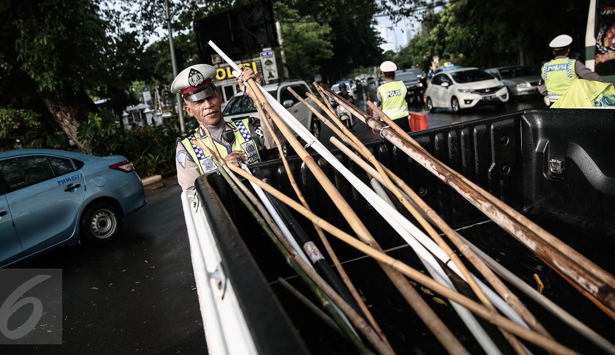 Petugas kepolisian mengamankan tongkat milik  suporter disekitar kawasan Gelora Bung Karno, Jakarta, Minggu (8/5/2016). (Liputan6.com/Faizal Fanani)