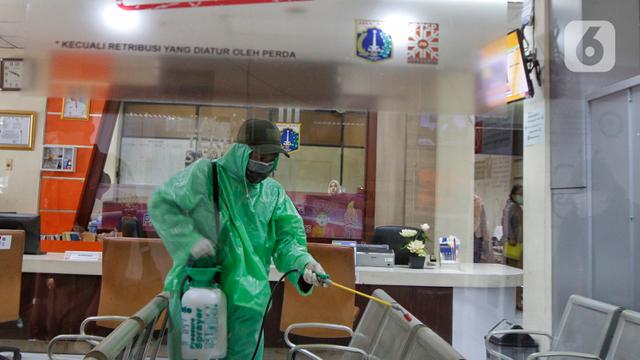Minim Fasilitas, Petugas Kenakan Jas Hujan Saat Semprotkan Cairan Disinfektan