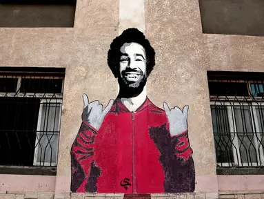 Mural dinding Mohamed Salah di pusat olahraga dan pemuda di Desa Nil Delta Nagrig, Mesir, Rabu (2/5). Warga mengaku bangga karena pemain Liverpool tersebut menyumbang jutaan poundsterling ke kampung halamannya. (AP Photo/Nariman El-Mofty)