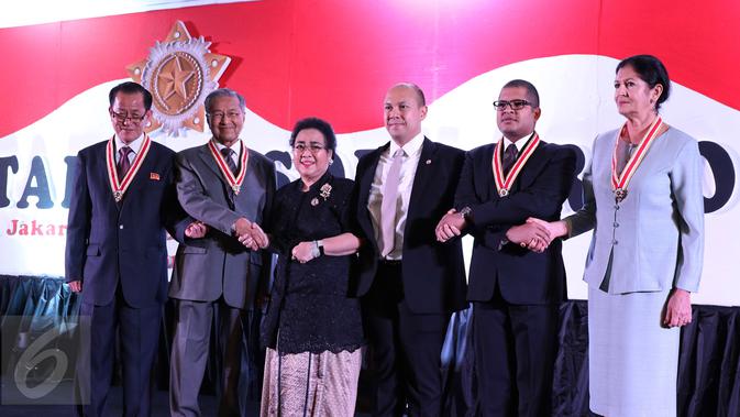 Pendiri Yayasan Pendidikan Soekarno (YPS), Rachmawati Soekarnoputri berjabat tangan dengan Mantan PM Malaysia Mahatir Mohamad (kedua kiri) usai penyerahan Anugerah Tanda Kehormatan Star of Soekarno di Jakarta, Minggu (27/9). (Liputan6.com/Herman Zakharia)