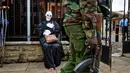 Polisi bersenjata melewati pengunjuk rasa saat berdemonstrasi menentang rencana pemerintah untuk menambang batu bara dan membuka PLTU, Nairobi, Kenya, Selasa (5/6). (AP Photo/Ben Curtis)