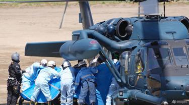 Personil darurat memindahkan orang yang diselamatkan di Shari, di pulau utara Hokkaido pada 24 April 2022. (Foto: Koki Sengoku/Kyodo News via AP)