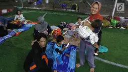 Warga korban Tsunami Anyer mengungsi di lapangan futsal Labuan, Banten, Minggu (23/12). Akibat adanya pengungsi, petugas medis dan Dinas Sosial dikerahkan untuk menangani pengungsi. (Liputan6.com/Angga Yuniar)