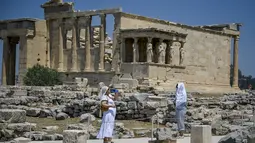Wisatawan melindungi diri dari matahari saat mengunjungi Acropolis di Athena, Yunani, Minggu (24/7/2022). Negara ini berada dalam cengkeraman gelombang panas yang dimulai pada 23 Juli dan akan berlangsung beberapa hari. Suhu diperkirakan akan mencapai 42 derajat Celcius (107 derajat Fahrenheit) di beberapa daerah.
(Louisa GOULIAMAKI / AFP)