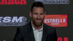 Pemain Barcelona FC, Lionel Messi tersenyum saat berpose dengan trofi Sepatu Emas keenamnya di Antiga Fabrica Estrella Damm, Barcelona, Spanyol (16/10/2019). Sebelumnya, Messi pernah merebutnya pada 2010, 2012 dan 2013. (AP Photo/Joan Monfort)
