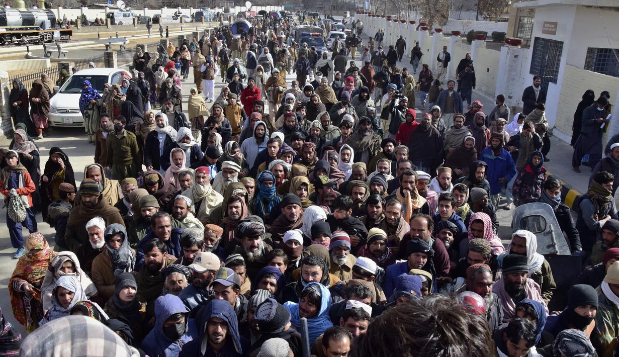 Orang-orang menunggu dalam antrean panjang untuk membeli karung tepung terigu bersubsidi dari sebuah tempat penjualan di Quetta, Pakistan, Kamis (12/1/2023). Orang-orang menderita akibat kenaikan harga tepung terigu di Pakistan baru-baru ini. (AP Photo/Arshad Butt)