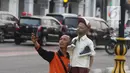 Petugas berselfie di kawasan pedestrian Kali Besar, Kota Tua, Jakarta, Rabu (11/7). Masyarakat sudah bisa mengakses area yang proyek revitalisasinya telah berlangsung sejak 2017 lalu, dan menghabiskan anggaran Rp 260 miliar. (Liputan6.com/Arya Manggala)