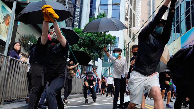 Demonstran mencoba menembakkan barang menggunakan sling shot saat demonstrasi di Hong Kong, Senin (11/11/2019). Ketegangan di Hong Kong semakin meningkat setelah polisi menembak seorang demonstran hingga kritis. (AP Photo/Vincent Yu)