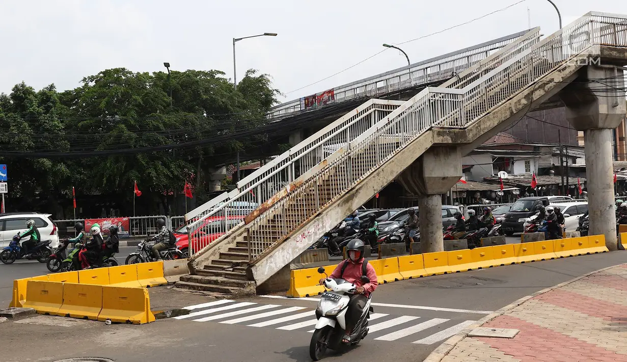 Suasana JPO di Jalan Dewi Sartika, Cawang, Jakarta Timur, berada di tengah jalan, Rabu (9/1). Adanya proyek pelebaran jalan menyebabkan posisi trotoar bergeser sehingga tangga JPO tersebut menjadi di tengah jalan. (Liputan6.com/Immanuel Antonius)