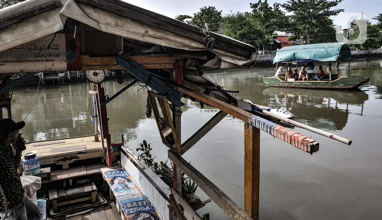 Lalu-lalang perahu eretan saat menyeberangkan warga di Kali Sunter, Rawa Badak, Jakarta, Rabu (20/1/2021). Hendi (40), salah satu penarik perahu eretan di Rawa Badak mengaku jasa transportasi alternatif ini masih diminati warga untuk menunjang aktivitas sehari-hari. (merdeka.com/Iqbal S. Nugroho)