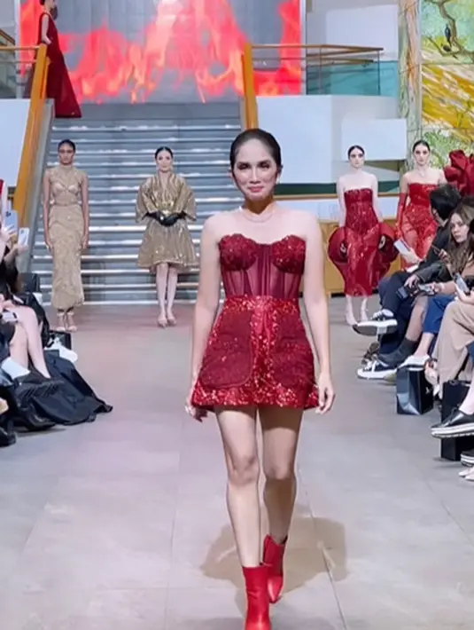 Tak kalah glamor, Ussy Sulistiawati kenakan two-piece yang terdiri dari bustier dan celana pendek. Makin seksi dengan boots merah [@ussypratama]