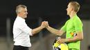 Kiper Copenhagen, Karl-Johan Johnsson, berjabat tangan dengan pelatih Manchester United, Ole Gunnar Solskjaer, pada laga Liga Europa di Stadion Rhein Energie, Senin (10/8/2020). MU menang tipis 1-0 atas Copenhagen.  (Wolfgang Rattay/Pool via AP)