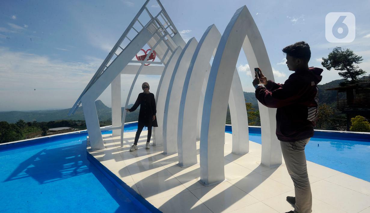 Wisatawan berfoto saat mengunjungi tempat wisata yang Instagrammable di kawasan Puncak Dua, Sukamakmur, Bogor, Jumat (6/1/2023). Meski kawasan Puncak Dua belum dikembangkan secara maksimal oleh Pemkab Bogor dan pemerintah pusat, warga seputar Jabodetabek dan Cianjur tetap antusias mengunjungi kawasan ini sebagai tempat wisata alternatif selain kawasan Puncak dan sekitarnya yang selalu didominasi kemacetan lalu lintas. (merdeka.com/Arie Basuki)