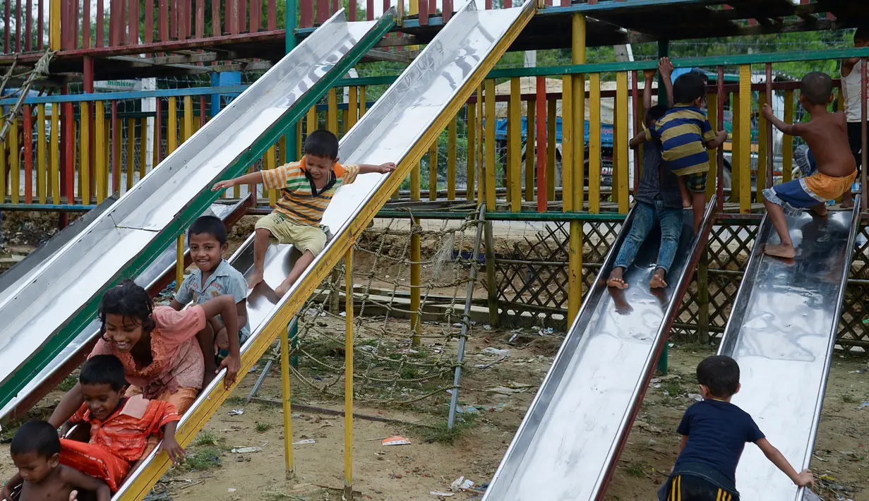 Anak-anak pengungsi Rohingya bermain di taman bermain yang ada di kamp Kutupalong, di Ukhia, Bangladesh pada 6 Oktober 2020. Lebih dari satu juta etnis Rohingya melarikan diri dari Myanmar dan menetap di Kutupalong yang merupakan salah satu kamp pengungsi terbesar di dunia. (Munir Uz Zaman/AFP)
