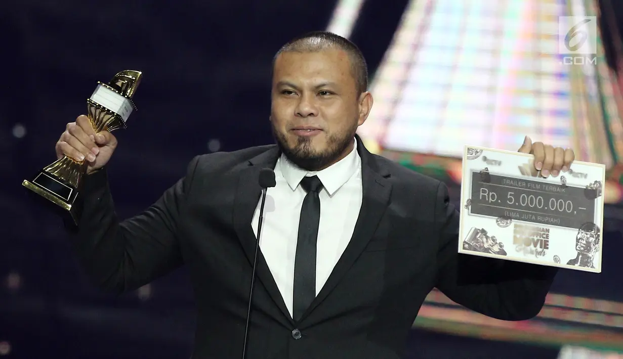 Sutradara film 'Pengabdi Setan', Joko Anwar mengangkat piala dalam acara IBOMA 2018 di STUDIO 6 EMTEK CITY, Jakarta, Jumat (23/3). Joko Anwar meraih penghargaan kategori trailer film terbaik. (Liputan6.com/Herman Zakharia)
