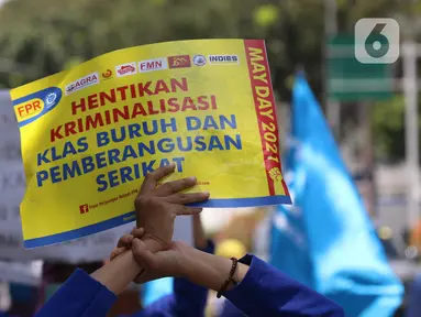 Salah satu poster yang dibawa oleh buruh dalam aksi memperingati Hari Buruh Internasional atau May Day di Jakarta, Sabtu (1/5/2021). Dalam aksinya mereka meminta pemerintah untuk mencabut Omnibus Law dan memberlakukan upah minimum sektoral (UMSK) 2021. (Liputan6.com/Angga Yuniar)