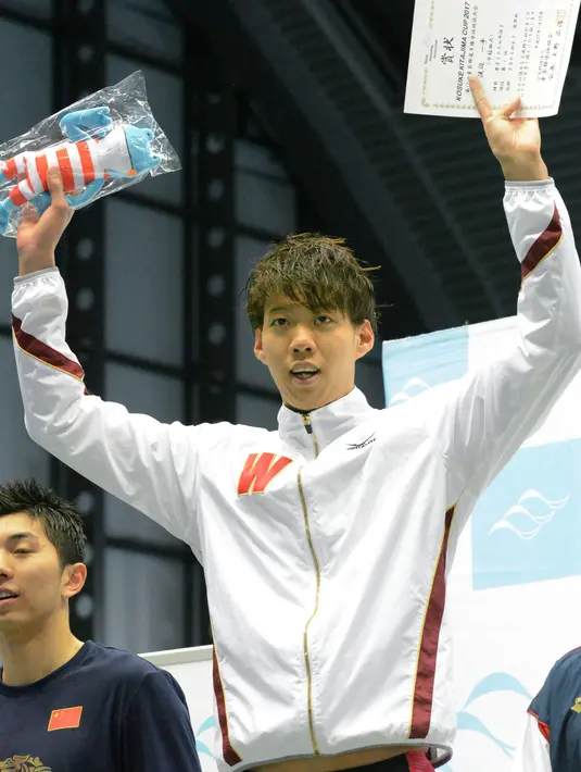 Ippei Watanabe saat berada di podium usai keluar sebagai juara pada kejuaraan Piala Kosuke Kitajima di Tokyo, Minggu (29/1). Watanabe mencatat waktu 2 menit 6.67 detik dalam kejuaraan tersebut sekaligus membuat rekor dunia.(AP PHOTO)