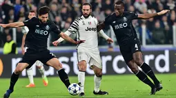 Penyerang Juventus, Gonzalo Higuain (tengah) berusaha membawa bola dari kawalan dua pemain Porto pada leg kedua 16 besar Liga Champions di Stadion Juventus, Turin, Italia, (15/3). Juventus menang atas Porto dengan skor 1-0. (AFP Photo/Giuseppe Cacace)