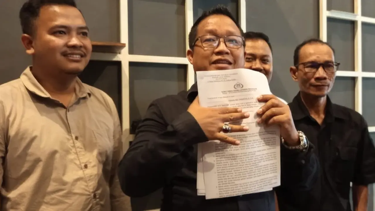 Koordinator tim kuasa hukum paslon 02, Yusuf Istanto menunjukan laporan pengaduan kepada anggota DPRD Kudus yang diduga menganiayai relawan paslon 02 ke Mapolres Kudus (Liputan6.com/Arief Pramono)