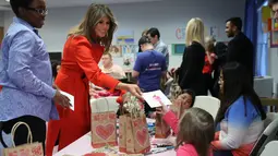 Istri Presiden AS Donald Trump, Melania Trump kartu valentine kepada seorang anak saat berkunjung ke Children's Inn di National Institute of Health (14/2). (AP Photo/Pablo Martinez Monsivais)