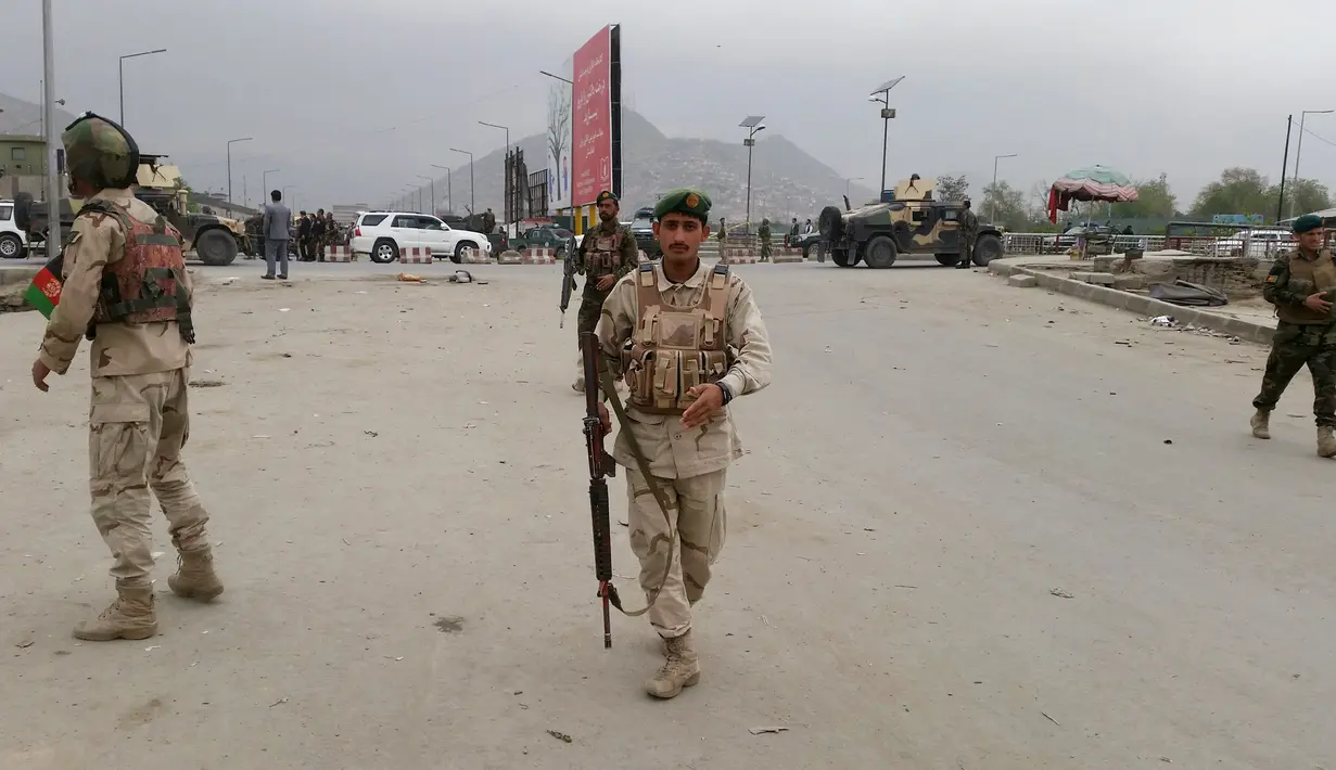 Anggota keamanan berjaga-jaga di lokasi ledakan di Kabul, Afghanistan, Selasa (19/4). Ledakan yang berasal dari sebuah serangan bom bunuh diri itu menyebabkan puluhan orang tewas dan sedikitnya 150 lainnya terluka. (REUTERS/Omar Sobhani)