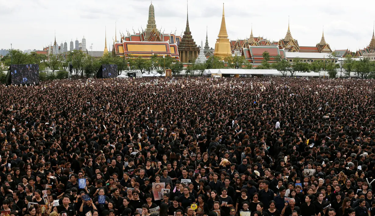 Tampak puluhan ribu pelayat memadati kawasan Grand Palace sambil menyanyikan rekaman lagu kerajaan, di Bangkok, Thailand, (22/10). Pihak berwenang mengatakan lebih dari 150.000 pelayat hadir. (REUTERS/Jorge Silva)