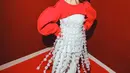 Quirky look ala Andien Aisyah yang memadukan cut-out sweater berwarna merah, tank top putih dengan aksen rumbai putih, dan loose pants warna senada seperti top-nya. [Instagram/andienaisyah]